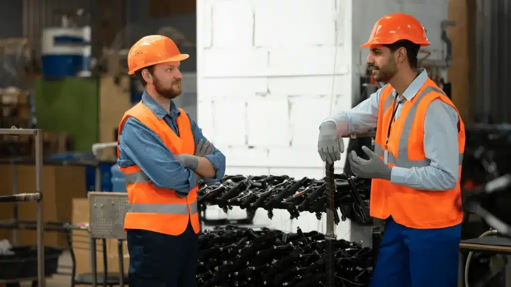 Workers and engineers operating equipment in a modern steel recycling facility