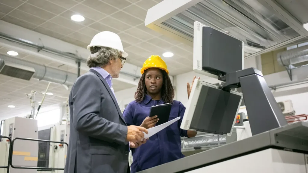 Lean Manufacturing Director reviewing production efficiency inside a steel manufacturing plant