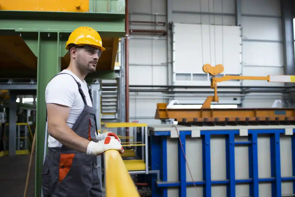 Maintenance manager inspecting heavy equipment inside a steel manufacturing plant