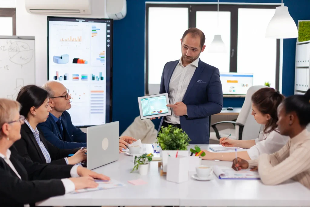 Manufacturing executives reviewing compensation, performance, and operational strategy in an industrial leadership meeting